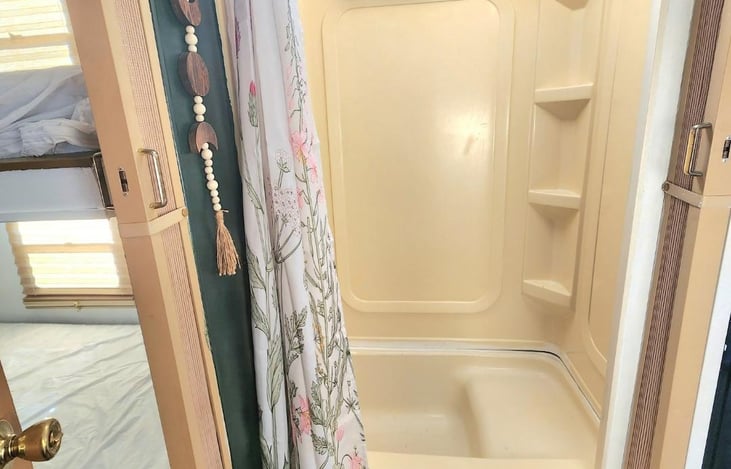 Shower Space is across from toilet room and has two accordion doors that can make the bathroom completely private. Has hot water heater. More than enough space for someone over 6'5 or tub for toddler.