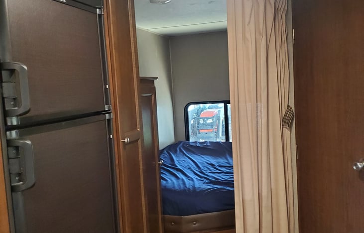 Full size bed with privacy curtain.