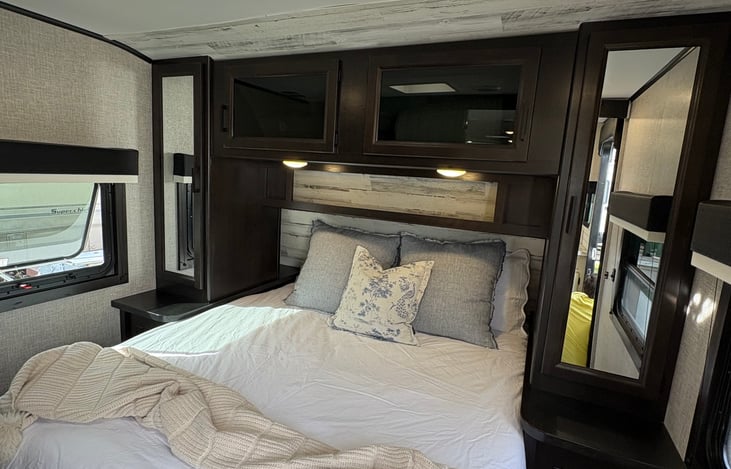 Master bedroom. Overhead storage both closed and open, as well as, two closets on either side of the bed.