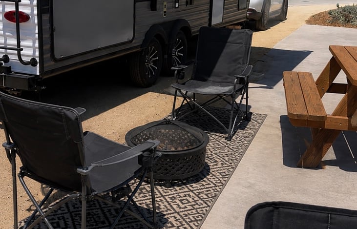 Relax outdoors under the awning with 4 comfortable chairs provided and an outdoor rug. Enjoy your morning coffee, family meals or unwind by a camp fire. Outdoor kitchen area with grill and fridge.
