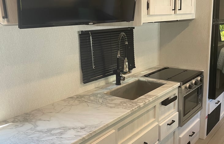 Plenty of counter space, and more storage room behind the TV that is directly across from the reclining sofa.