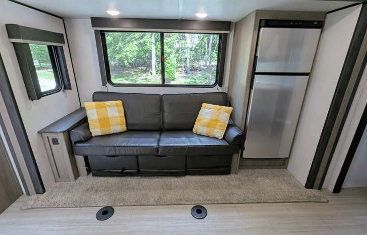 Spacious and cozy interior with well-equipped kitchen, large refrigerator, ample counter space, electric fireplace, TV, stereo, and bunks.