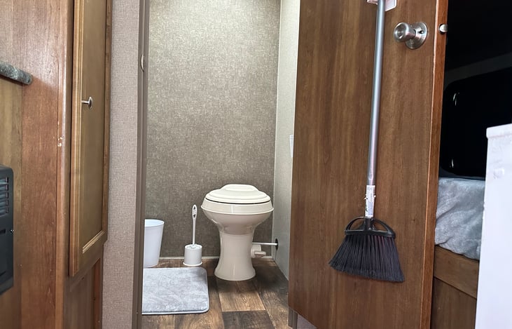 This camper has a clean bathroom that has a toilet and shower.