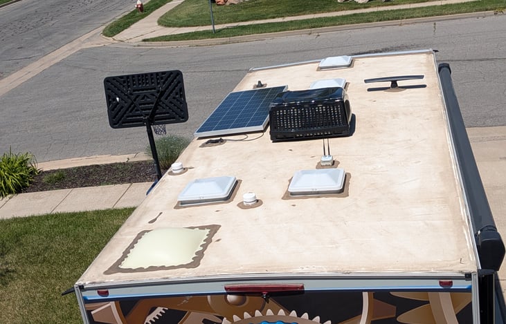 AC unit. Solar panel to charge battery. Wi-Fi ranger antenna. Four air vents and a shower sky light.