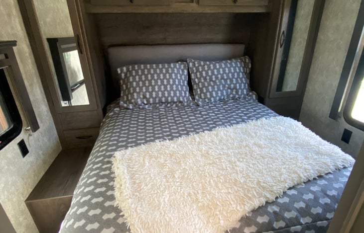 Master bedroom with queen bed and storage closets.