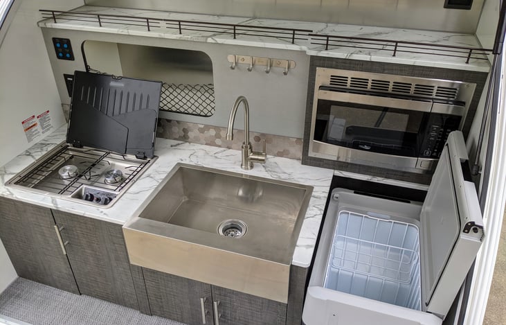 The Intech Luna Rover teardrop trailer is designed for camp cooks! Enjoy upscale camp food when you have access to a fridge, microwave, sink and stove top.