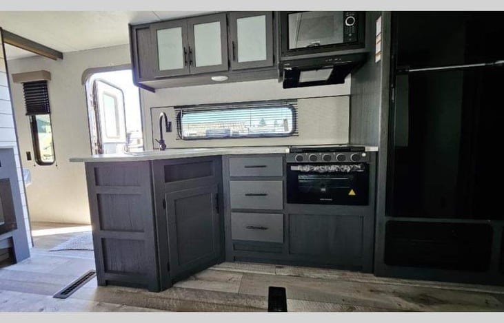 Kitchen sink, microwave, gas stove top and oven and cupboards fully stocked with just about everything you need.