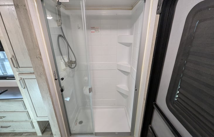 Privacy and convenience! This second full bath features a walk-in shower, porcelain toilet, and its own exterior entrance—perfect for quick access without tracking dirt through the whole rig.