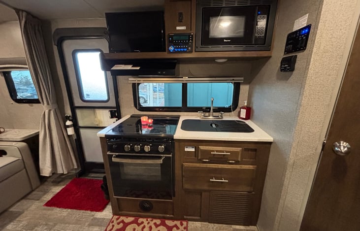 Kitchen complete with three burner stove/oven range, and microwave oven.