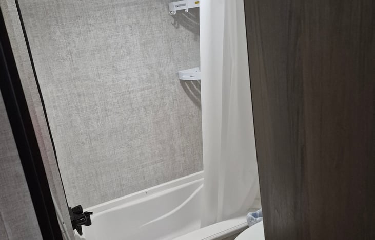 Mini-tub with removable shower head. Please use camper/RV toilet paper only. Do not flush feminine products. Towels, shampoo, conditioner, body wash and toilet paper are provided.