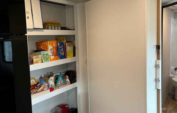 entertainment center opens to a large pantry