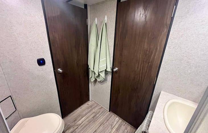 Bathroom with shower, sink, and toilet. Enterance to hallway and main bedroom.