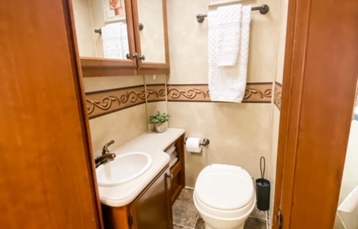 Bathroom equipped with toilet paper, basic toiletries,  first aid essentials, hair dryer + bath and hand towels