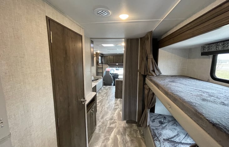 bunkbeds with white water proof sheet on both with big 2nd TV installed for kids