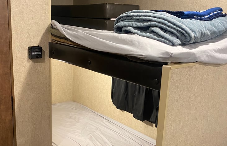 Bunk beds. Bottom bunk has window, top bunk has privacy curtain
