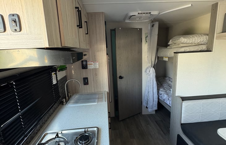 Modern kitchen area with bunk beds in the back—comfortable and functional for families.