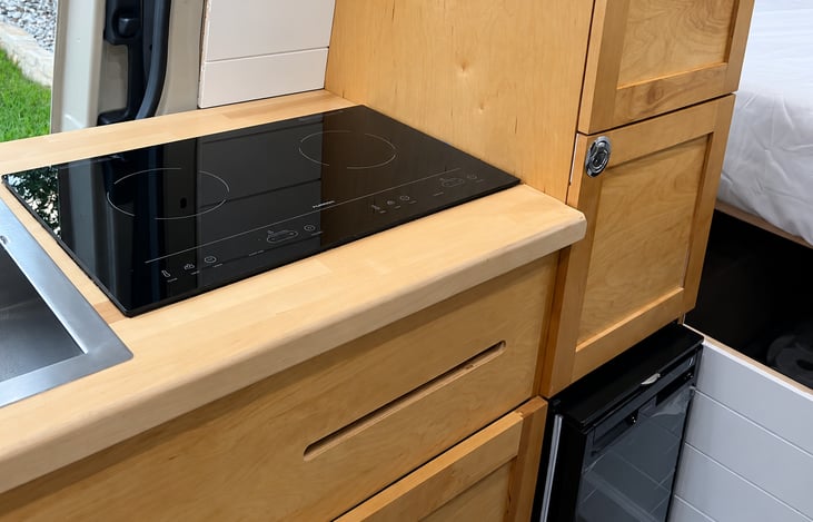 Cook wherever the road takes you! The modern kitchen features an induction cooktop, generous counter space and everything you need to enjoy meals with a view.