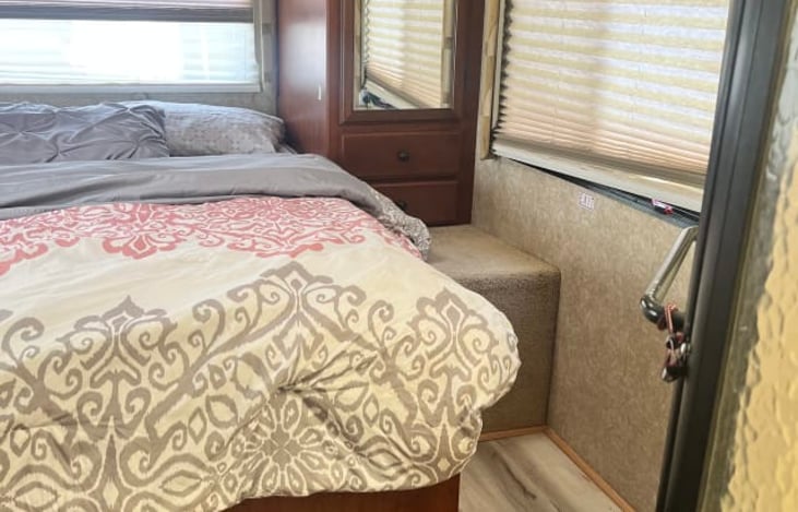 bedroom has a small TV as well as a queen size bed.