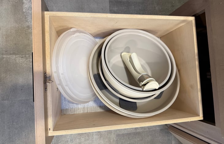 Space-saving stackable pots and pans with lids and a removable handle for compact storage. Handle must be removed before cooking.