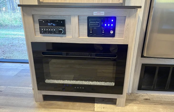 Smart Roku TV, fireplace and music system keeps the entertainment going in this spacious and cozy camper.