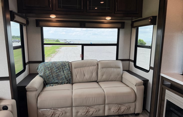 Star Comfort: Power-reclining luxury theater seating and a large tri-fold sofa facing panoramic scenic windows.