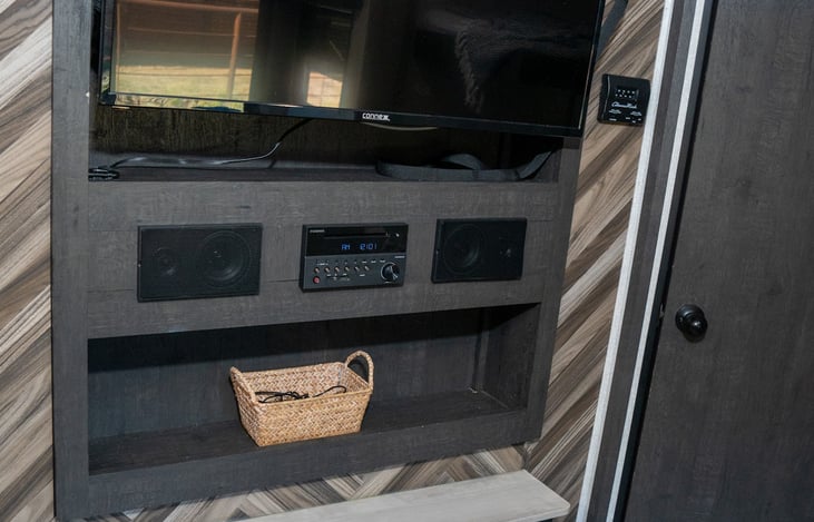 entertainment center features a flat screen tv, a fireplace that can be ambient or put out real heat, and a duel zone speaker system for indoor and outdoor listening.