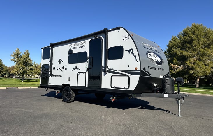 Front-quarter exterior showing entry side, awning area, and Black Label graphics.