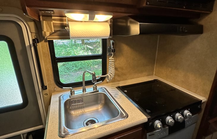 Kitchen sink with paper towel holder and extension spray faucet for easy cleaning. Propane gas stove
