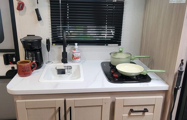 Two burner gas range with cookware, coffee maker and dishwashing necessities included.