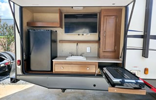 Large RV with outdoor kitchen, fireplace, and TVs