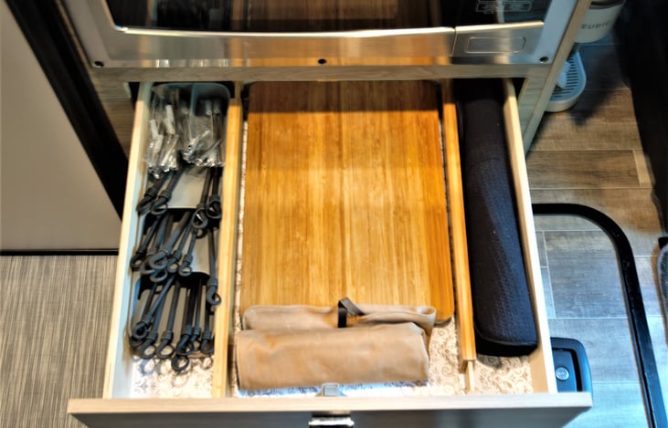 Silverware, cutting board, wine opener, and drying mat.