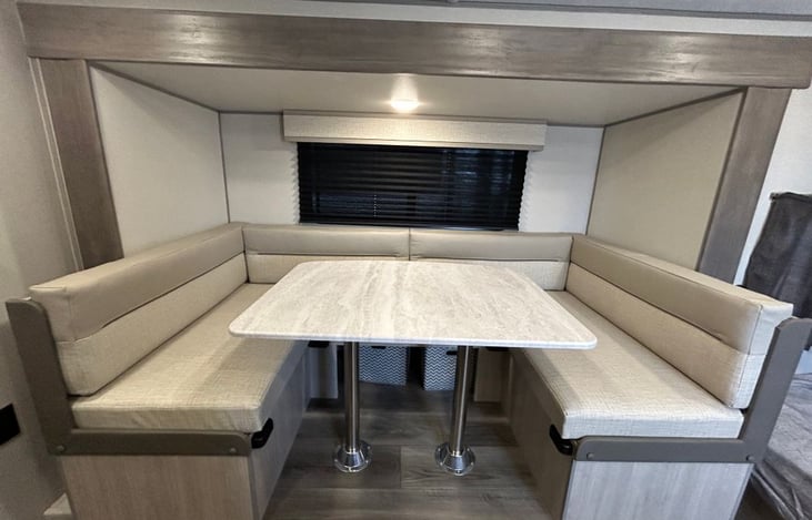 Large seating around this table that has storage underneath and can fold down into a bed.