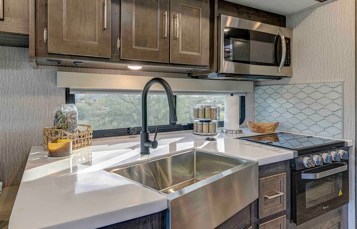 Kitchen, large residential farmhouse sink, and solid-surface countertops