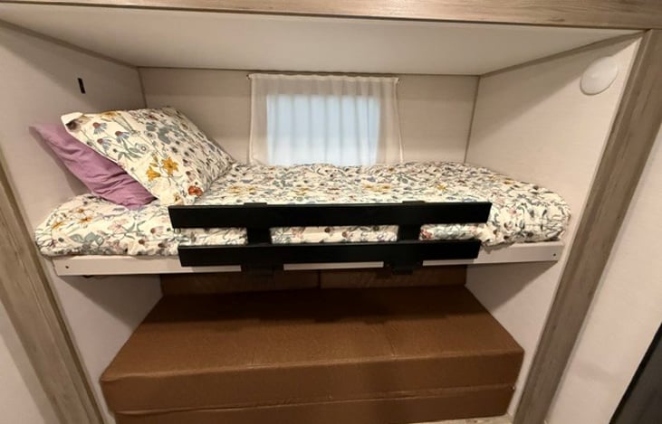 Bunk on left side of trailer. A foldout sofa "full" underneath bunk.