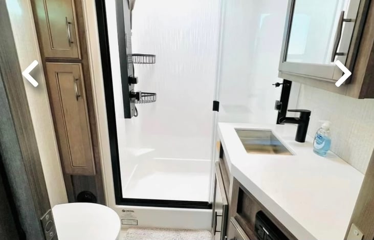 Bathroom features larger walk in shower and ample counter space as well as storage for towels and toiletries