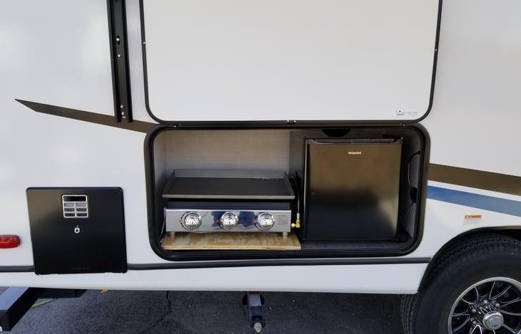 Outdoor kitchen with propane grill and electric fridge