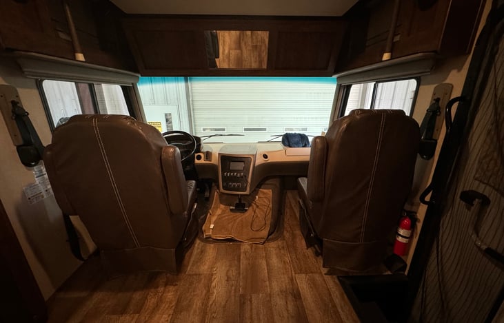 Driver & passenger seats with bed up. The seats swivel around and shades come down.