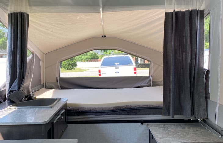 One sleep area. Both sleep areas feature memory foam mattresses that can be heated and a curtain for privacy.