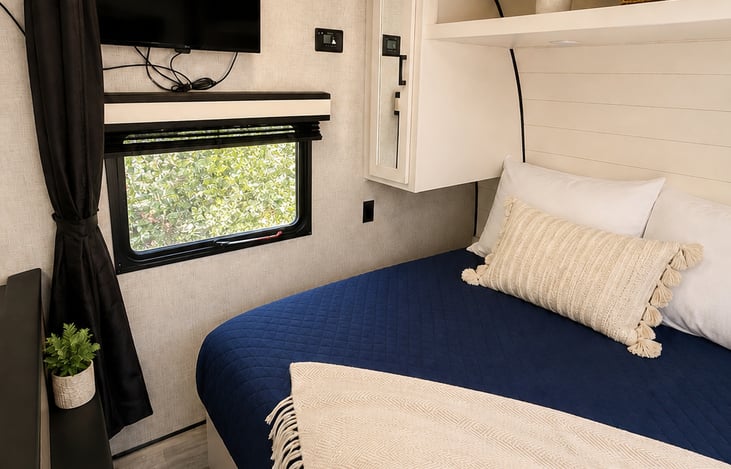Smart TV swivels between queen bedroom, dining room, bunk bed area so everyone can enjoy their favorite shows anywhere inside the RV