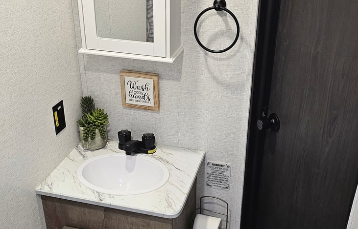Bathroom sink with updated medicine cabinet.