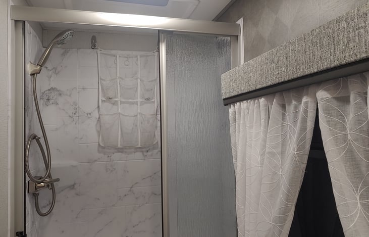 Shower in the rear. Creates more space than other Class C floor plans of this size. My 6 ' 2" son fits comfortably.