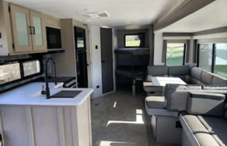 Spacious living room with slide out gives you plenty of room to sit around the table.  The table also converts into a queen size bed.  There is tons of bin storage under every seat!