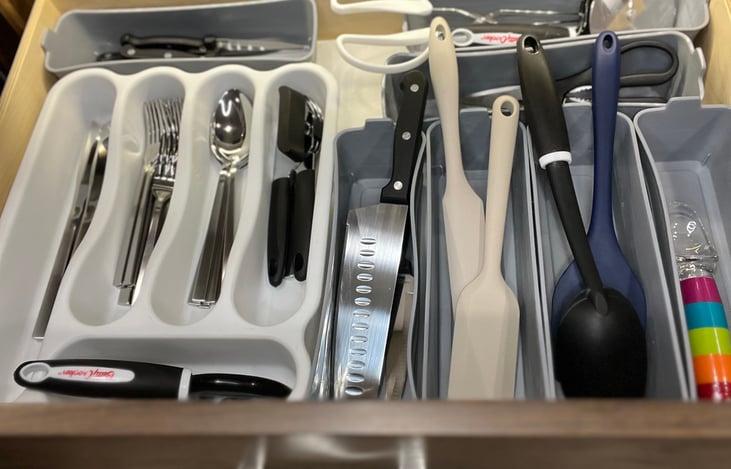 Lighted drawers include kitchen utensils and tableware.
