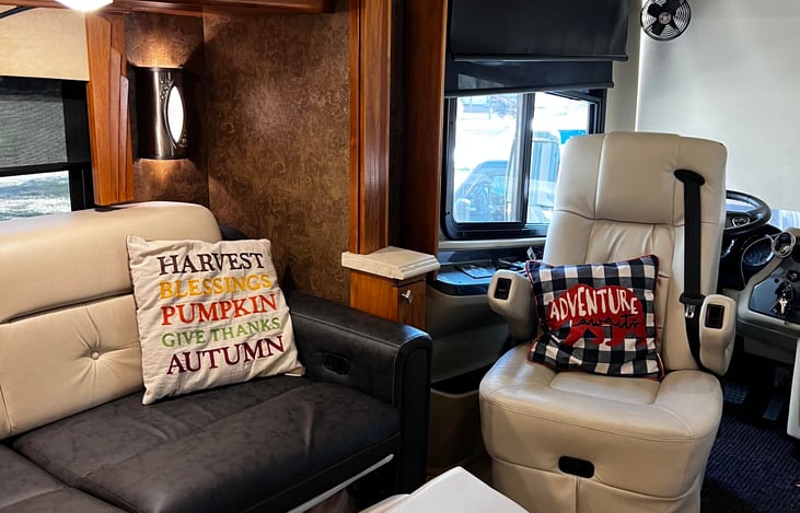 The 36GH Tiffin offers a front living room featuring a swivel captain's chair, providing comfort and flexibility for occupants.