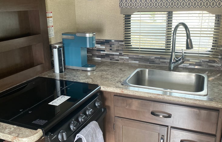 Keurig with coffee and assorted tea pods provided. Gas cooktop, large sink. Extra counter space pops up to side of the stove. Pots and basic cook wear provided.