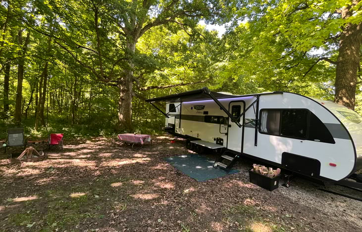 Large awning to provide shade and cover from the weather, screen door,  outdoor kitchen with outdoor fridge and flattop grill