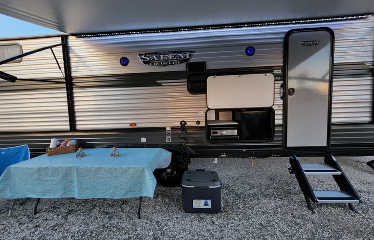 Outdoor kitchen with Refrigerator and grill.