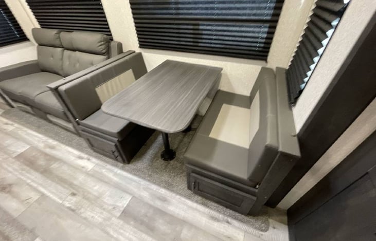 View of sofa and dining room which both fold out to full beds.