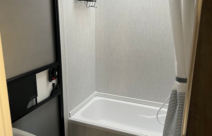 Shower with upgraded shower head installed. 
Shampoo, Conditioner, Body Wash, 2 towels and wash cloths, shower mat all included in rental