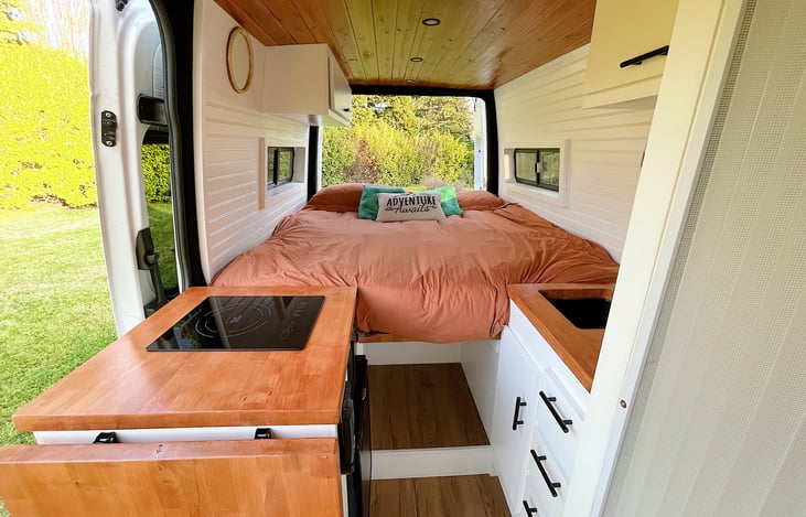 Kitchen with extendable countertop for additional space. Sink with adjustable hot water and storage. Dinette converts for near king size bed.